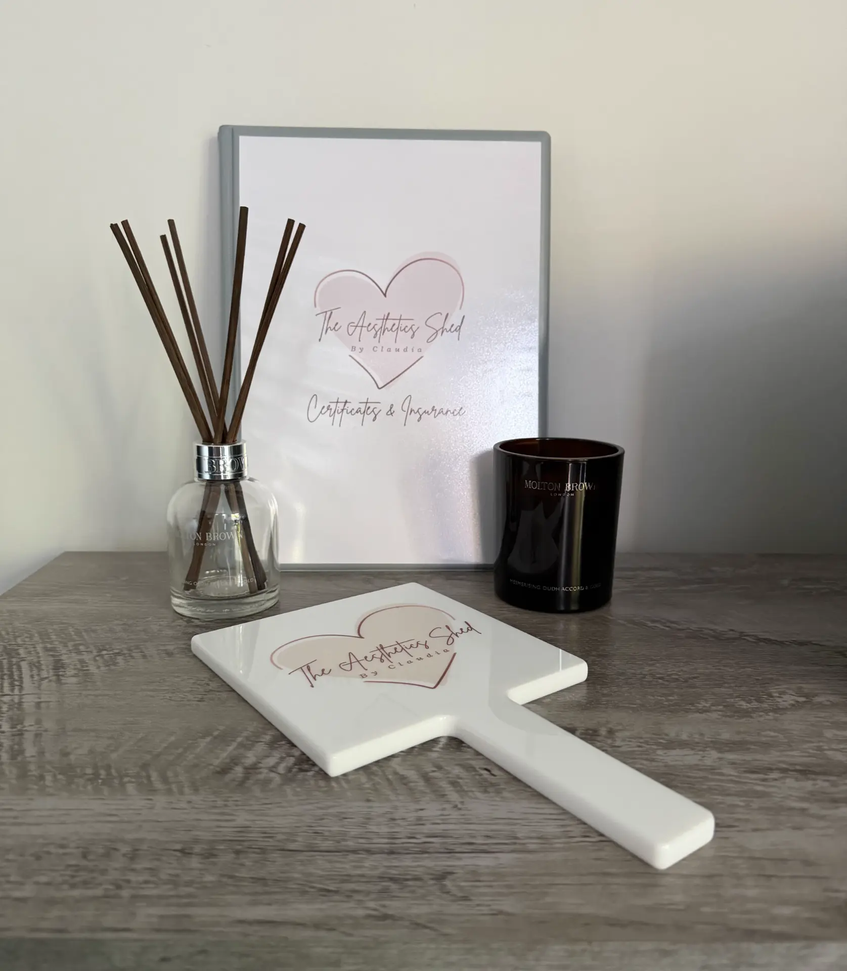 Branded hand mirror and certificates at The Aesthetics Shed by Claudia